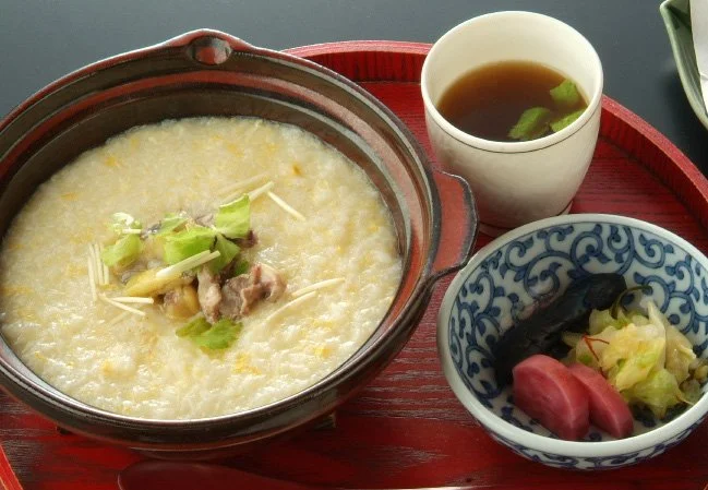 土鍋に仕立てた特製すっぽん鍋を卓上で斜め上から写し、澄んだスープと具材が見える料理写真